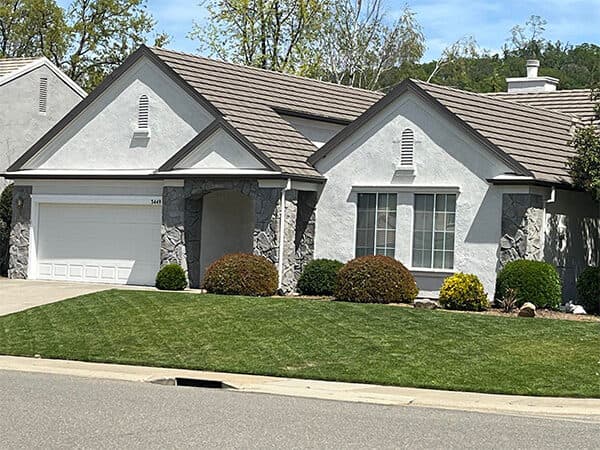 Light gray home exterior with white trim and stone porch columns.